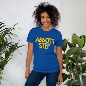 May include: A royal blue t-shirt with the text "Abbott Step" in yellow lettering.