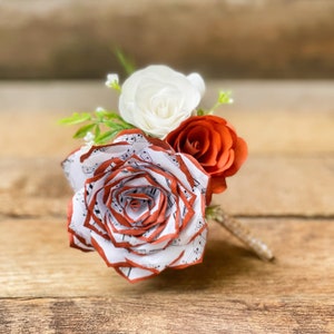 Music note paper rose boutonniere shown in burnt orange - Customizable colors
