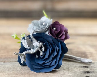 May include: A blue, purple, and gray paper flower bouquet with a silver dragon figurine.