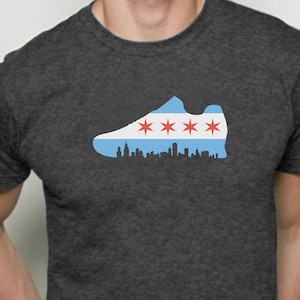 May include: A dark gray t-shirt with a silhouette of a running shoe. The shoe is filled with the Chicago flag, featuring white and blue stripes with six red stars.