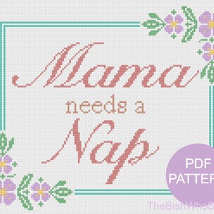 May include: Cross-stitch pattern with the text "Mama needs a Nap" in pink and brown. The design is framed in teal with floral accents in purple and green. A PDF PATTERN label is in the lower right corner.