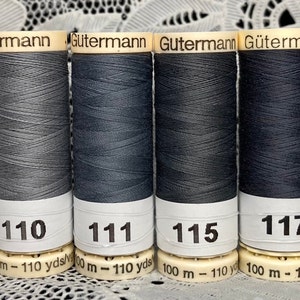 May include: Six spools of Gütermann thread in shades of gray and blue. The spools are labeled with the numbers 100, 110, 111, 115, 117, and 125. Each spool has 100 meters (110 yards) of thread.
