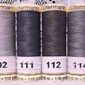May include: Six spools of Gutermann thread in various shades of gray, from light beige to dark charcoal. The spools are labeled with the numbers 70, 102, 111, 112, 114, and 116.