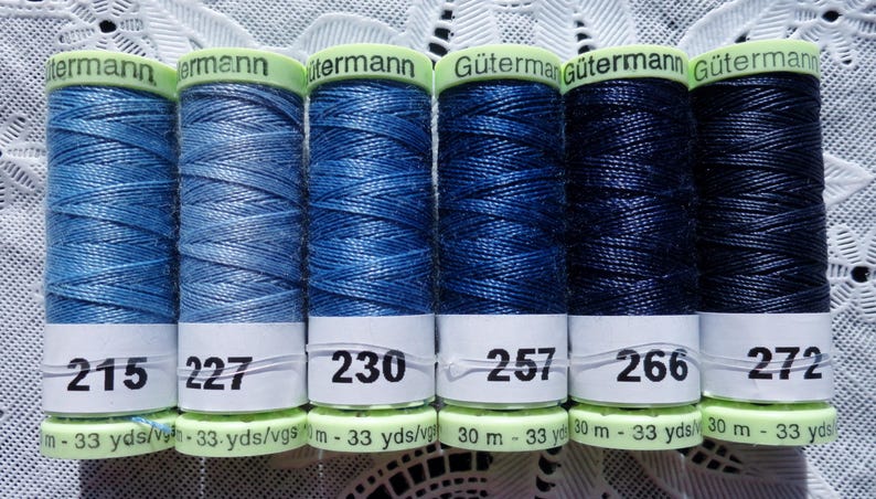 May include: Six spools of G&uuml;termann thread in shades of blue, from light to dark. The spools are labeled with numbers 215, 227, 230, 257, 266, and 272. Each spool has a length of 33 yards.