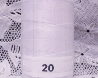 May include: A white spool of thread with a white label that says "20" on it.