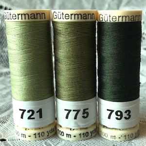May include: Three spools of Gütermann thread in shades of green. The spools are labeled with the numbers 721, 775, and 793. Each spool contains 110 yards of thread.
