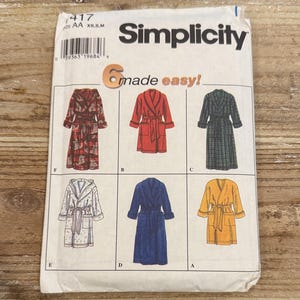 May include: A Simplicity sewing pattern featuring six robe designs. The pattern includes a variety of styles, from a red patterned robe to a solid blue robe. The text "6 made easy!" is visible.