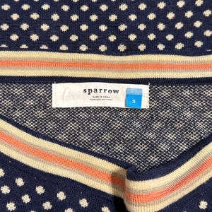 May include: Navy blue sweater with white polka dots and striped accents in cream and coral. The label reads "sparrow" and "S". Made in China.