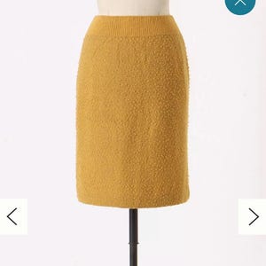 May include: A mustard yellow knitted skirt with a textured surface.