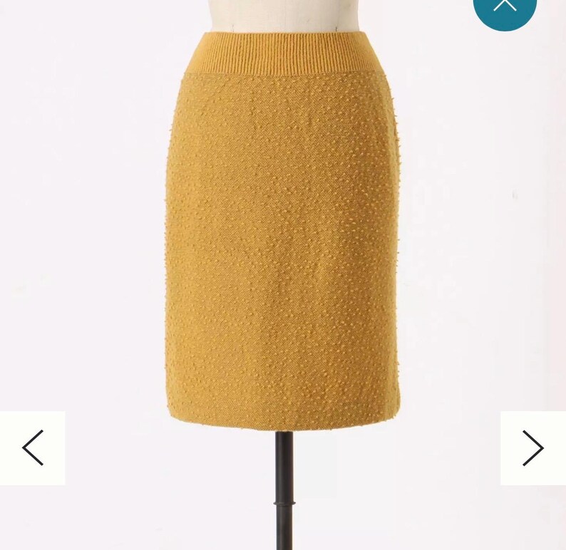 May include: A mustard yellow knitted skirt with a textured surface.
