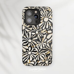 May include: Black and white phone case with a floral pattern. The flowers are stylized and have a gold metallic accent.