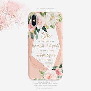 Peut inclure: Une coque de téléphone rose avec un motif floral et des accents dorés. La coque présente le texte "She is clothed with strength & dignity and she laughs without fear of the future Proverbs 31:25".