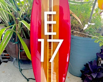 Placa con el número de la casa en la playa costera con diseño de tabla de surf en color rojo atardecer.
