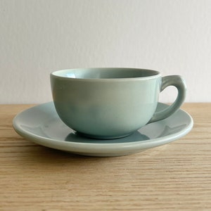 Peut inclure: Une tasse à thé et une soucoupe en céramique bleu clair. La tasse a une forme arrondie et une poignée. La soucoupe est de forme ronde simple.