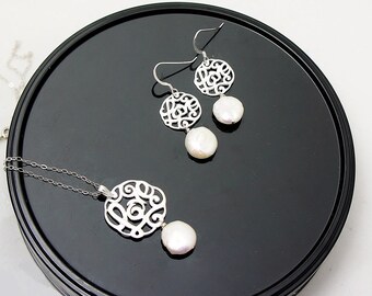 May include: A silver necklace and earrings set with a delicate filigree design and pearl accents. The necklace features a pendant with a circular filigree design and a single pearl drop. The earrings have a similar filigree design with a pearl drop on each earring.