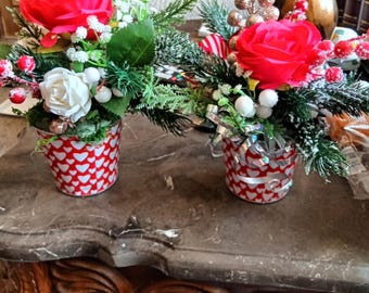 Deux petites compositions florales dans des boîtes en métal en forme de cœur, parfaites pour un rebord de fenêtre de cuisine ; comment les disposer sur une table basse