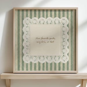 May include: A framed artwork featuring a white lace doily on a green and white striped background. The frame is light brown. The text on the doily reads: "Your favorite quotes, song lyrics, or text."