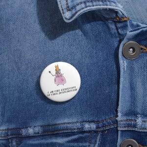 May include: A white button with a cartoon mouse wearing a crown and pink dress, holding a wand. The text "I AM THE EXECUTIVE OF THIS DYSFUNCTION" is printed below the mouse illustration.