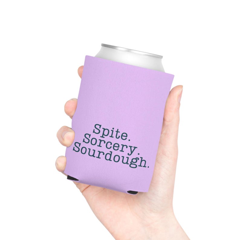 Can cooler featuring a dark serif font design that reads “Spite. Sorcery. Sourdough.” printed on a purple background.
