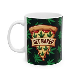 Puede incluir: Taza de cerámica blanca con fondo negro y un patrón de hojas de marihuana verdes. Una rebanada de pizza con salsa roja y queso está en el centro de la taza con el texto "GET BAKED" en una pancarta.