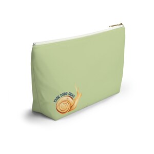 T-bottom pouch in moss green with a mushroom and the words Gorgeous Goblin Gear on the front and a cute snail with a positive message of You're doing great! on the back. Black zipper