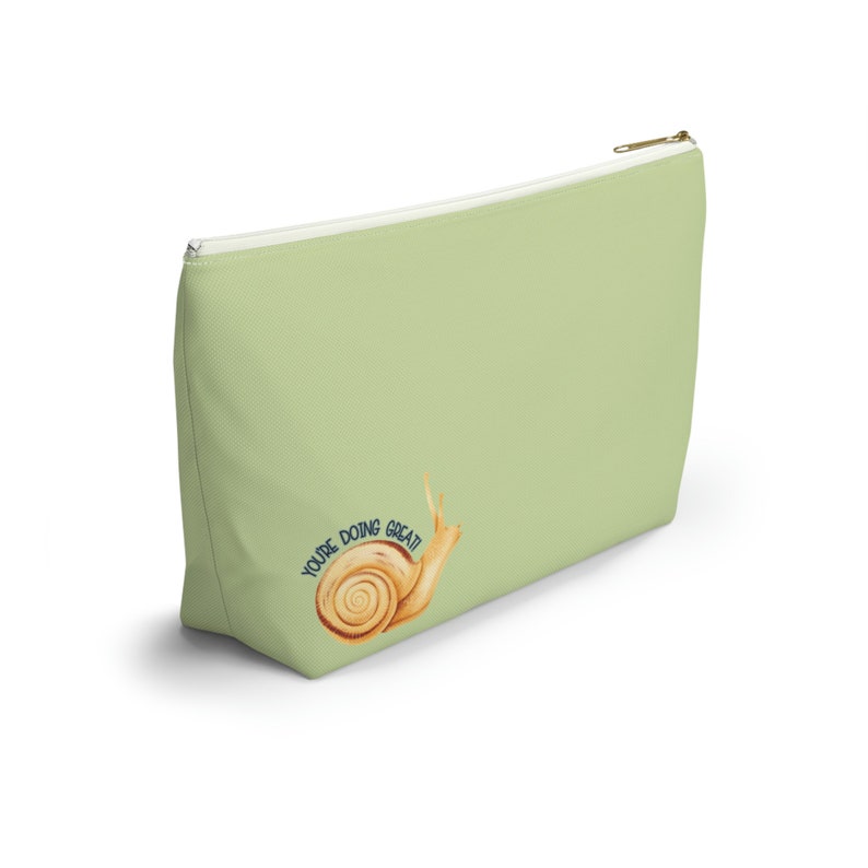 T-bottom pouch in moss green with a mushroom and the words Gorgeous Goblin Gear on the front and a cute snail with a positive message of You're doing great! on the back. Black zipper
