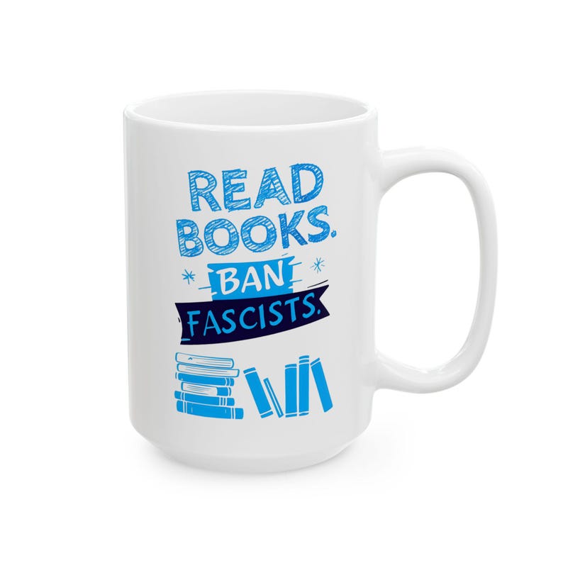 ceramic mug featuring bold blue hand-drawn text that reads "Read Books Ban Fascists" with illustrated books beneath the text.