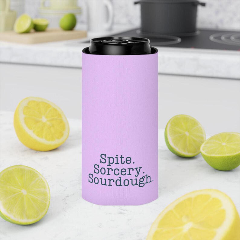 Can cooler featuring a dark serif font design that reads “Spite. Sorcery. Sourdough.” printed on a purple background.