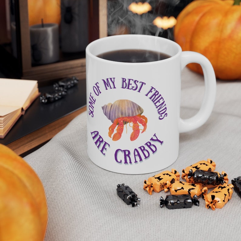 White ceramic mug featuring a cute hermit crab and the phrase “Some of My Best Friends Are Crabby” in a fun, beachy font.