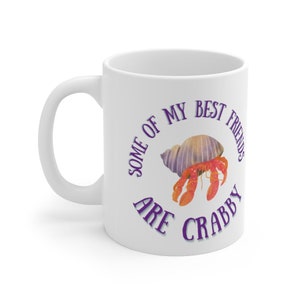 White ceramic mug featuring a cute hermit crab and the phrase “Some of My Best Friends Are Crabby” in a fun, beachy font.