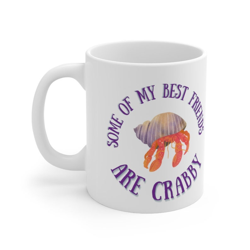 White ceramic mug featuring a cute hermit crab and the phrase “Some of My Best Friends Are Crabby” in a fun, beachy font.
