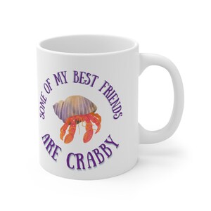 White ceramic mug featuring a cute hermit crab and the phrase “Some of My Best Friends Are Crabby” in a fun, beachy font.