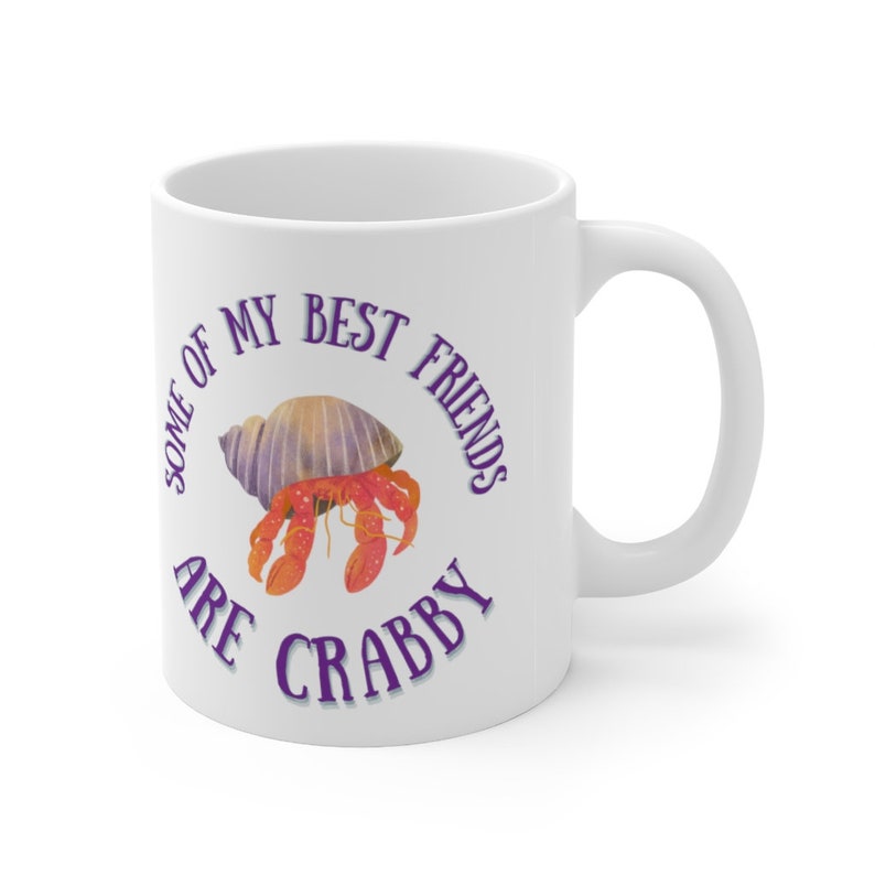 White ceramic mug featuring a cute hermit crab and the phrase “Some of My Best Friends Are Crabby” in a fun, beachy font.