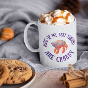 White ceramic mug featuring a cute hermit crab and the phrase “Some of My Best Friends Are Crabby” in a fun, beachy font.
