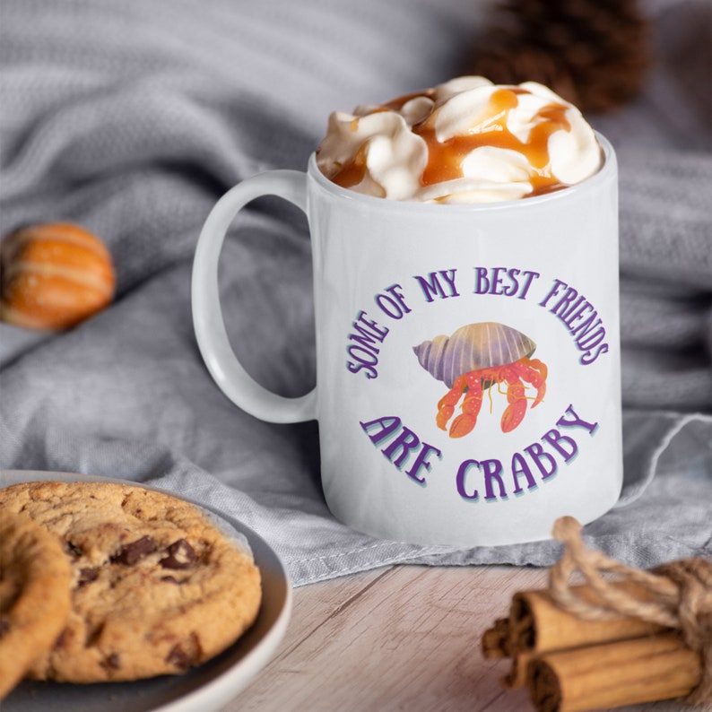 White ceramic mug featuring a cute hermit crab and the phrase “Some of My Best Friends Are Crabby” in a fun, beachy font.