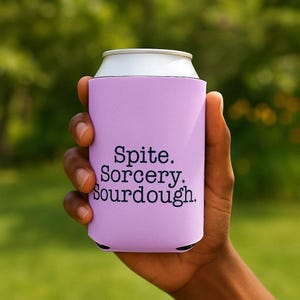 Can cooler featuring a dark serif font design that reads “Spite. Sorcery. Sourdough.” printed on a purple background.