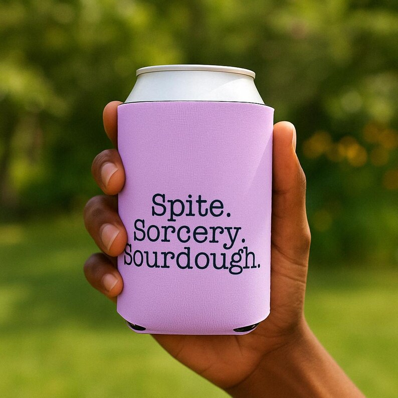 Can cooler featuring a dark serif font design that reads “Spite. Sorcery. Sourdough.” printed on a purple background.
