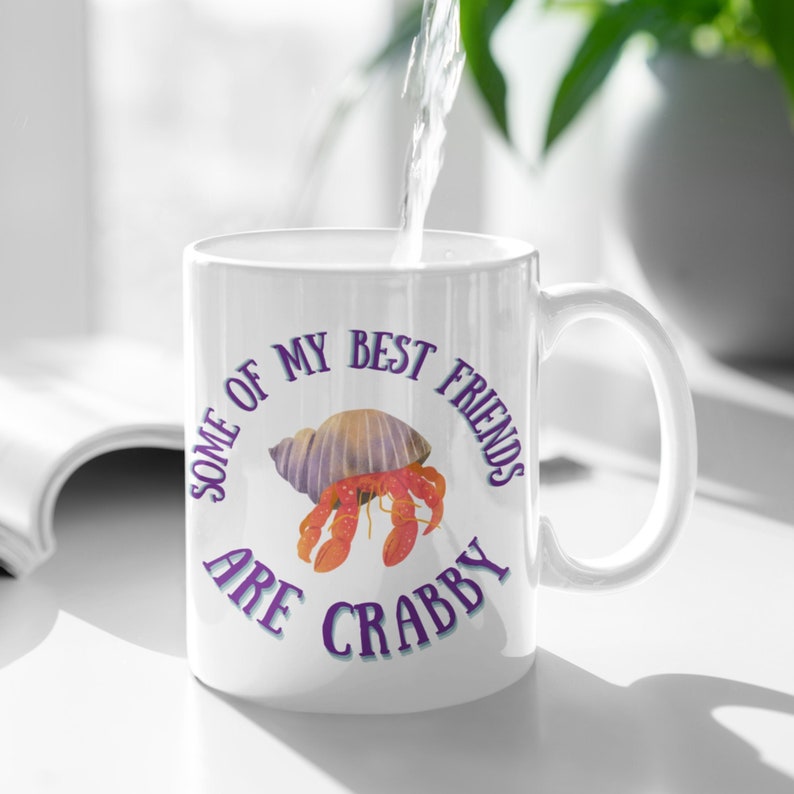 White ceramic mug featuring a cute hermit crab and the phrase “Some of My Best Friends Are Crabby” in a fun, beachy font.