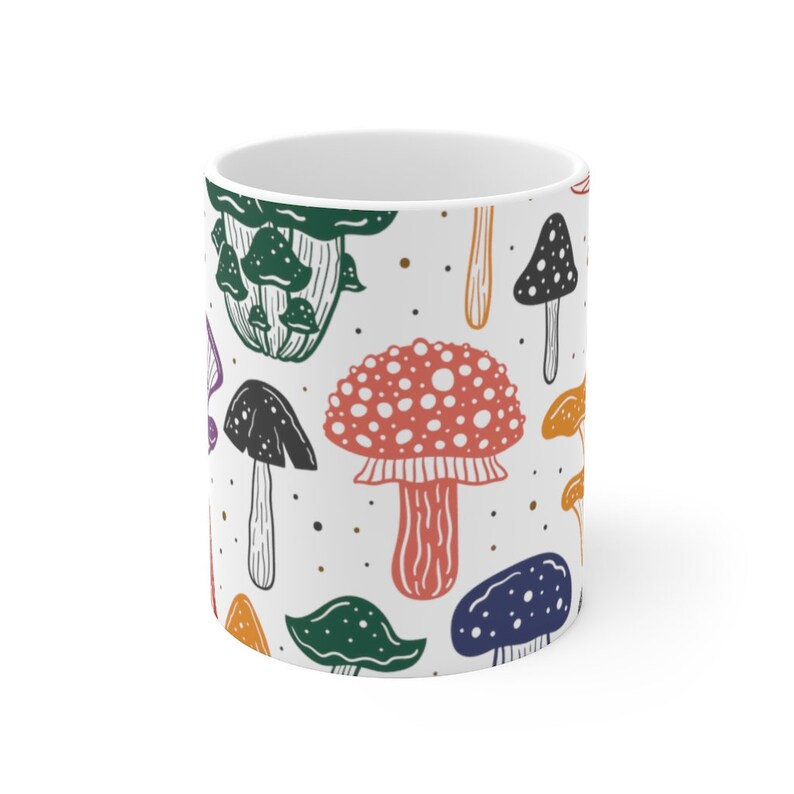 White ceramic mug featuring colorful illustrations of various mushrooms, perfect for mushroom enthusiasts and those who love nature-inspired designs.