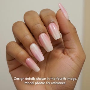May include: A hand displaying long, coffin-shaped artificial nails. The nails have a gradient effect, transitioning from a pearly white at the tips to a soft pink at the base. The image includes text that reads: "Design details shown in the fourth image. Model photos for reference."