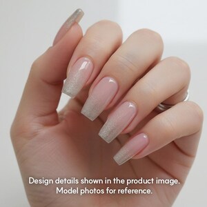May include: A hand with long, square-shaped nails. The nails have a light pink base with a silver glitter gradient at the tips. The image includes the text: "Design details shown in the product image. Model photos for reference."