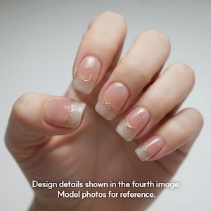 May include: Close-up of a hand with manicured nails. The nails feature a clear base with a glittery silver tip and a delicate gold design along the edge. The text at the bottom reads: Design details shown in the fourth image. Model photos for reference.