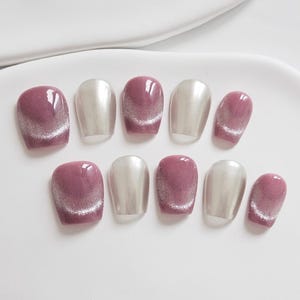 May include: A set of ten artificial nails in a variety of shapes. The nails alternate between a mauve color with a silver shimmer and a metallic silver color. The nails are arranged on a white surface.