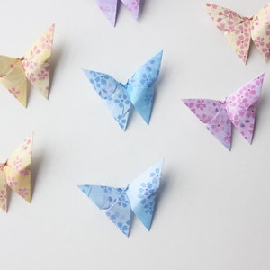 May include: A collection of origami butterflies in various colors, including yellow, blue, and purple. Each butterfly has a floral pattern.