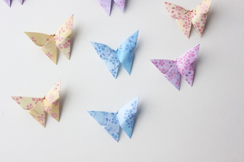 May include: A collection of origami butterflies in various colors, including yellow, blue, and purple. Each butterfly has a floral pattern.
