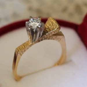 18 ct solid gold diamond ring, with a gold “leaf” enclosing the diamond on one side.