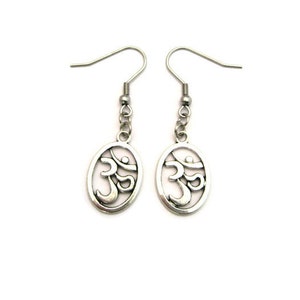 May include: Silver earrings with a delicate oval design featuring the Om symbol.