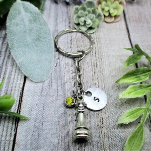 May include: Silver keychain with a chess piece charm, a yellow rhinestone, and a silver charm with the letter 'S'.