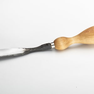 May include: A wooden handled metal scraper tool with a flat blade. The tool is made of metal with a wooden handle.