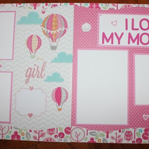 May include: Pink and white scrapbook page with a chevron pattern and hot air balloon graphics. The page has two photo spaces and the text "I love my mother" and "Bundle of Joy".
